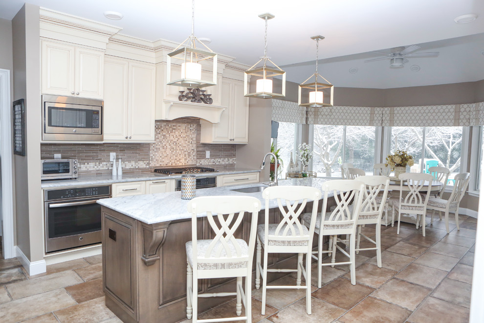 Eat-in kitchen - large transitional galley ceramic tile eat-in kitchen idea in Newark with an undermount sink, raised-panel cabinets, white cabinets, quartz countertops, stainless steel appliances, an island, gray backsplash and stone tile backsplash
