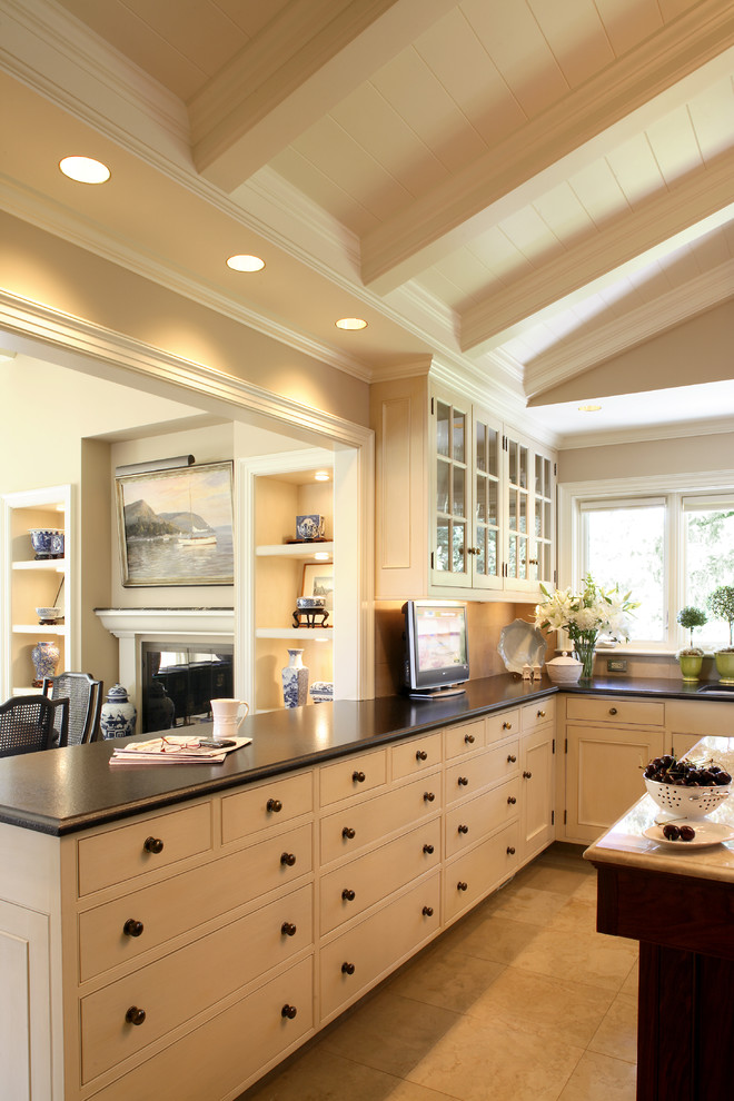 Modelo de cocina clásica con armarios con rebordes decorativos, puertas de armario blancas y salpicadero beige
