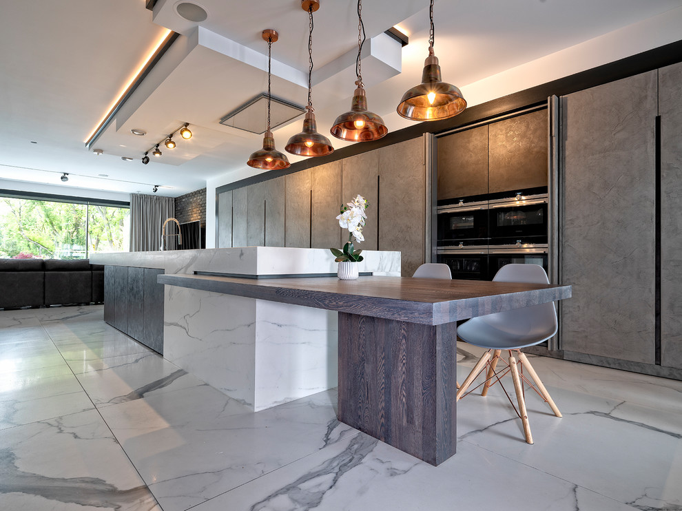 Einzeilige, Mittelgroße Moderne Küche mit flächenbündigen Schrankfronten, grauen Schränken, Marmor-Arbeitsplatte, Marmorboden, Kücheninsel, weißem Boden und schwarzen Elektrogeräten in Surrey