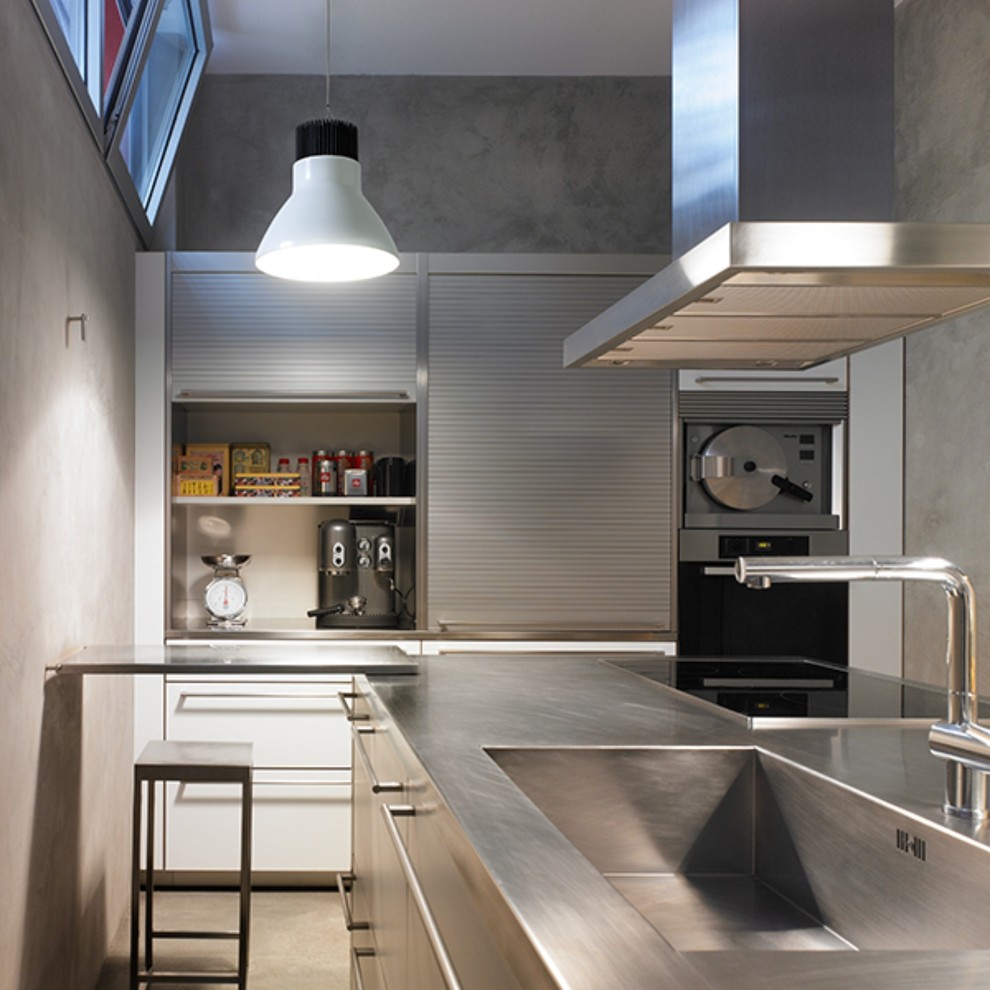 Foto di una cucina moderna di medie dimensioni con lavello a vasca singola, ante in acciaio inossidabile, top in acciaio inossidabile e elettrodomestici in acciaio inossidabile