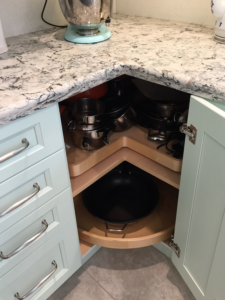 Immagine di una cucina chic di medie dimensioni con lavello sottopiano, ante con riquadro incassato, ante verdi, paraspruzzi bianco, elettrodomestici in acciaio inossidabile e top bianco