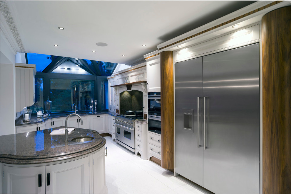 Immagine di una cucina classica con lavello sottopiano, ante con riquadro incassato, ante grigie, top in granito, elettrodomestici in acciaio inossidabile e pavimento in gres porcellanato