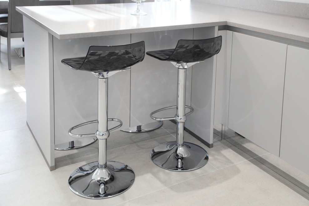 Light grey handleless kitchen with modern bar stools Modern