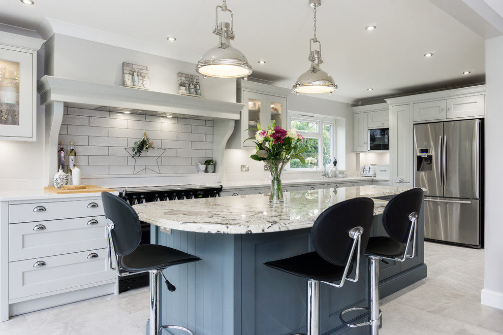 Design ideas for a large traditional grey and white single-wall kitchen/diner in Other with a built-in sink, shaker cabinets, grey cabinets, engineered stone countertops, white splashback, ceramic splashback, stainless steel appliances, ceramic flooring, an island, grey floors and white worktops.
