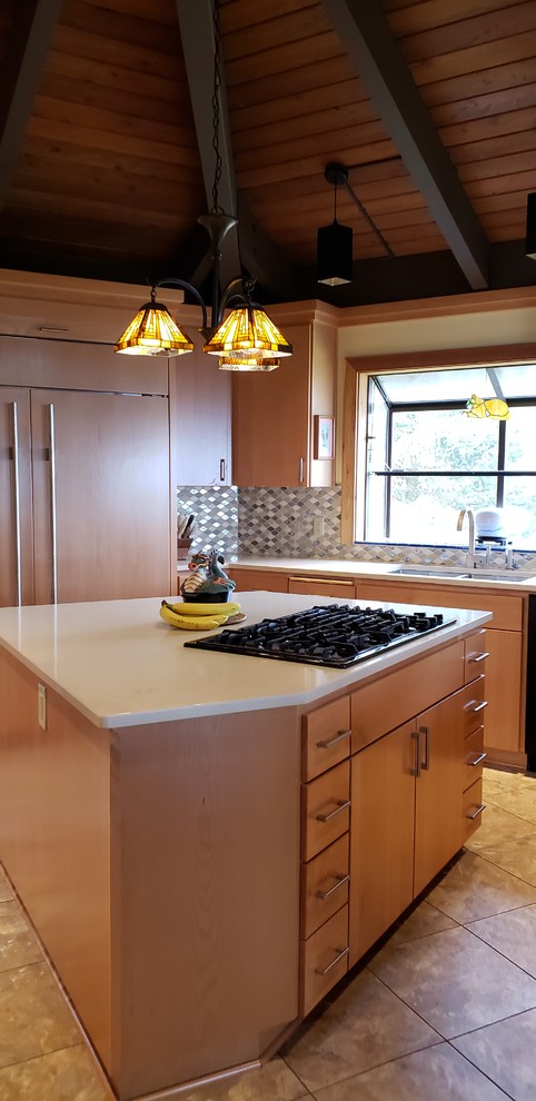 Inredning av ett klassiskt mellanstort beige beige kök, med en dubbel diskho, släta luckor, skåp i ljust trä, bänkskiva i kvartsit, flerfärgad stänkskydd, stänkskydd i glaskakel, integrerade vitvaror, laminatgolv, en köksö och beiget golv