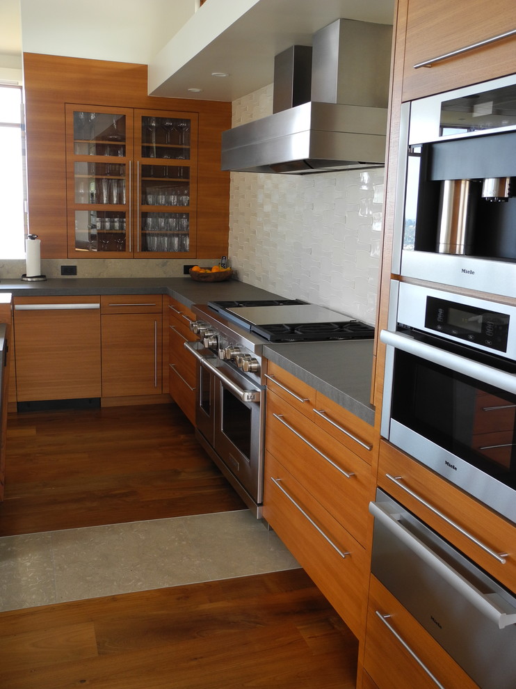 Ejemplo de cocina contemporánea con fregadero integrado, puertas de armario de madera clara y salpicadero blanco