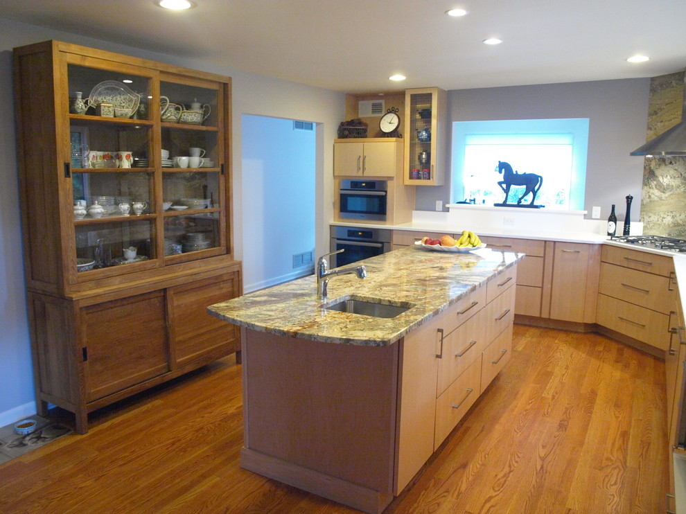 Inspiration for a mid-sized modern u-shaped light wood floor eat-in kitchen remodel in Newark with a drop-in sink, flat-panel cabinets, light wood cabinets, granite countertops, stainless steel appliances and an island