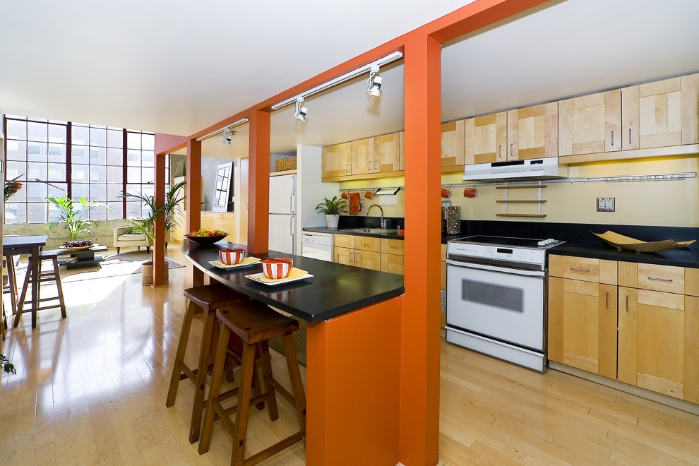 Imagen de cocina lineal contemporánea abierta con electrodomésticos blancos y puertas de armario de madera clara