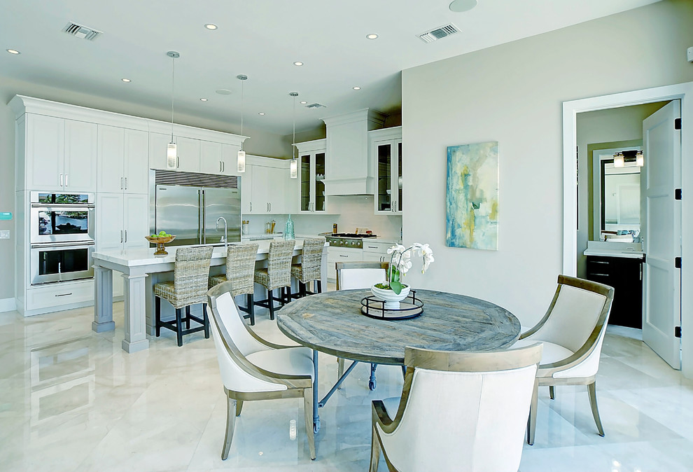 Mid-sized island style l-shaped marble floor and beige floor eat-in kitchen photo in Miami with an undermount sink, recessed-panel cabinets, white cabinets, quartz countertops, white backsplash, porcelain backsplash, stainless steel appliances and an island