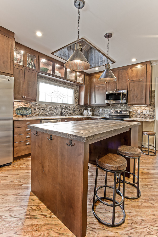 Photo of a medium sized rustic l-shaped kitchen in Atlanta with shaker cabinets, dark wood cabinets, wood worktops, multi-coloured splashback, stainless steel appliances, medium hardwood flooring and an island.