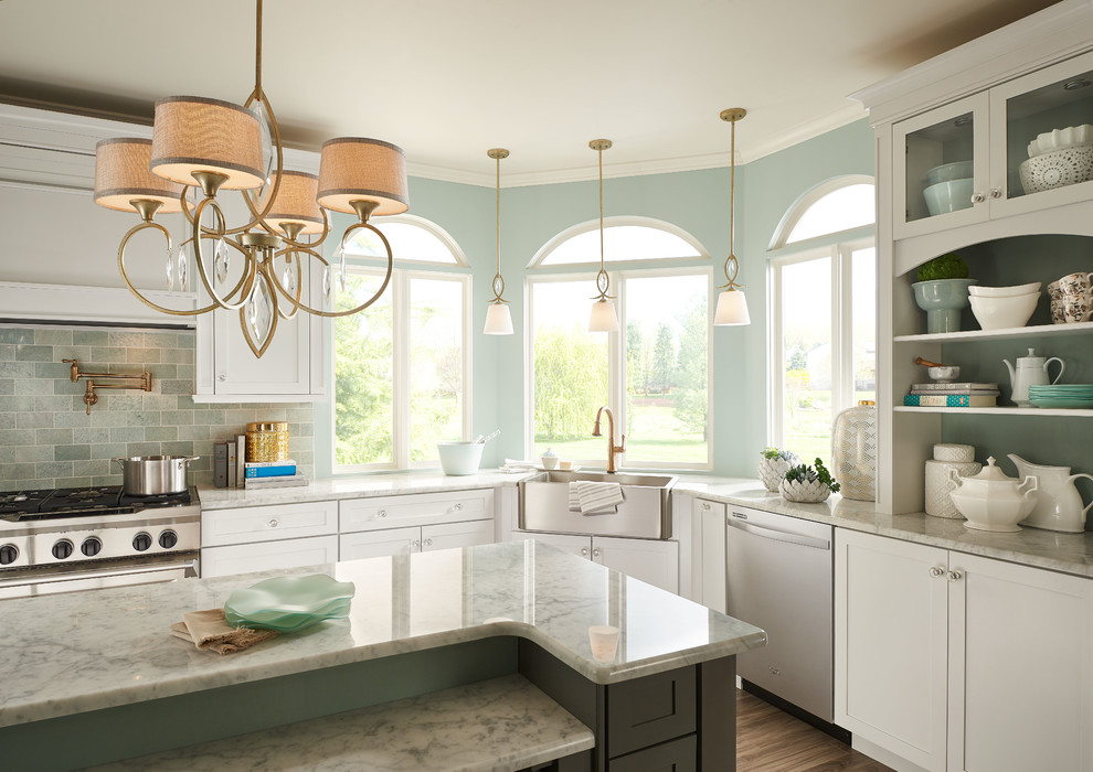 Inspiration for a mid-sized timeless medium tone wood floor kitchen remodel in Charlotte with a farmhouse sink, shaker cabinets, white cabinets, stainless steel appliances and an island