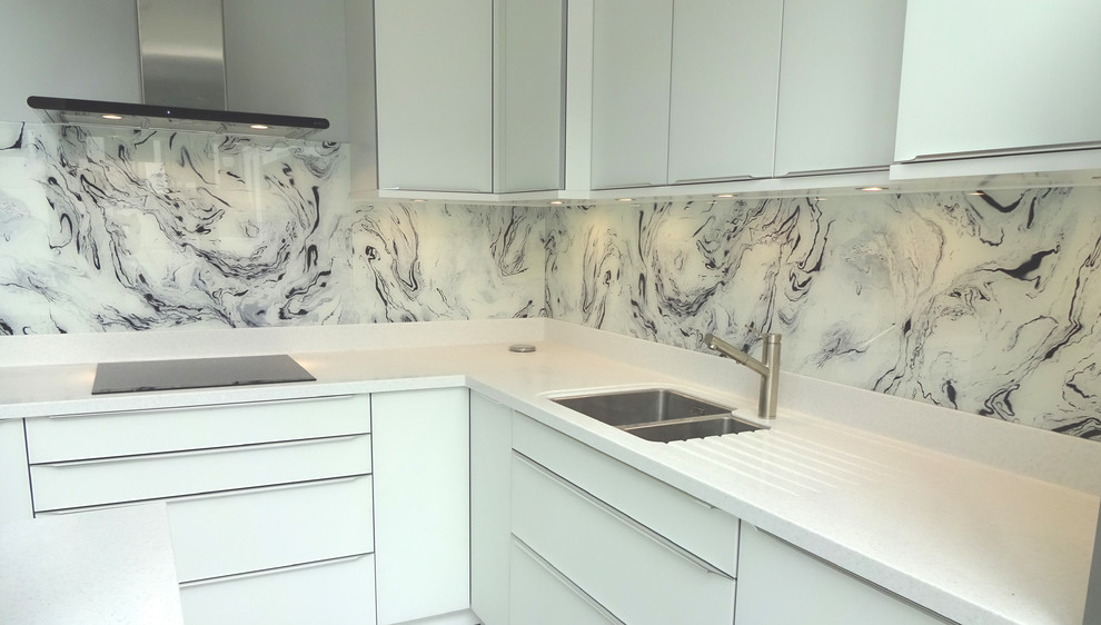 Photo of a contemporary kitchen in London with white splashback and glass sheet splashback.