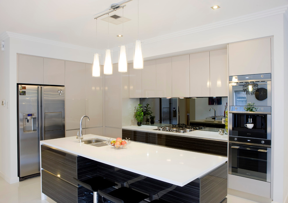 This is an example of a large contemporary l-shaped kitchen/diner in Adelaide with a double-bowl sink, dark wood cabinets, engineered stone countertops, mirror splashback, stainless steel appliances, porcelain flooring and an island.