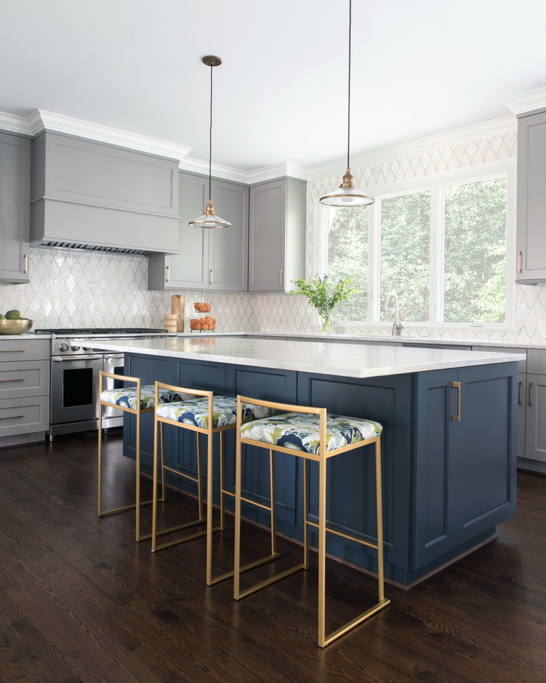 This is an example of a traditional l-shaped kitchen in Charlotte with shaker cabinets, grey cabinets, white splashback, stainless steel appliances, dark hardwood flooring, an island, brown floors and white worktops.