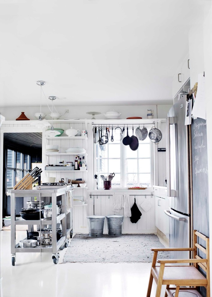 オーデンセにある高級な小さなインダストリアルスタイルのおしゃれなキッチン (オープンシェルフ、白いキャビネット、ステンレスカウンター、磁器タイルの床、アイランドなし) の写真