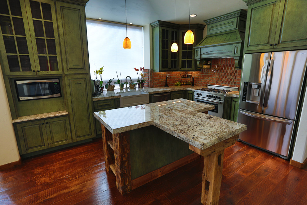 Mittelgroße Eklektische Wohnküche in L-Form mit Landhausspüle, profilierten Schrankfronten, grünen Schränken, Granit-Arbeitsplatte, Küchenrückwand in Rot, Küchengeräten aus Edelstahl, braunem Holzboden und Kücheninsel in Portland
