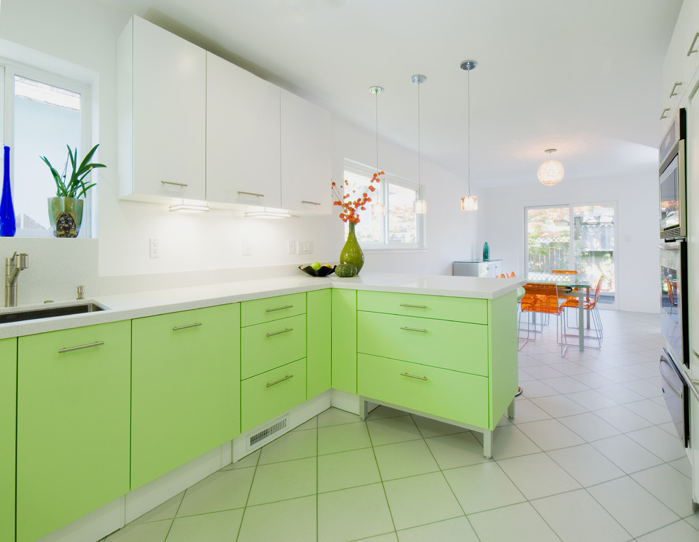 Example of a mid-sized trendy u-shaped ceramic tile eat-in kitchen design in San Francisco with an undermount sink, flat-panel cabinets, green cabinets, quartz countertops, white backsplash, stone slab backsplash, paneled appliances and a peninsula
