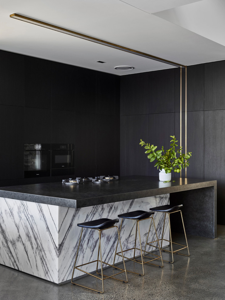 This is an example of a large modern u-shaped kitchen/diner in Sunshine Coast with a submerged sink, dark wood cabinets, granite worktops, window splashback, black appliances, concrete flooring, an island and black worktops.