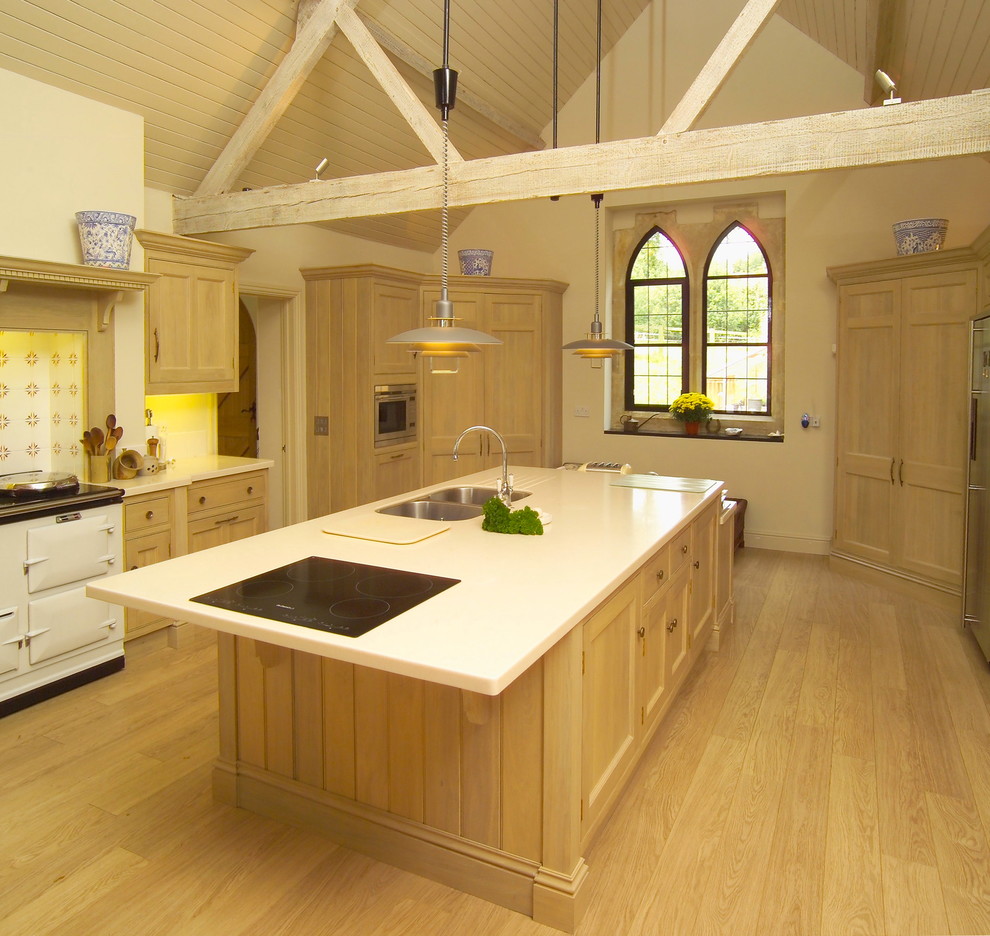 Esempio di un cucina con isola centrale contemporaneo con top in superficie solida e parquet chiaro