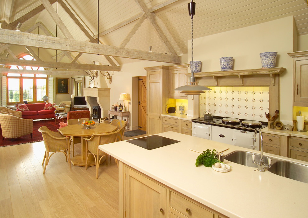 Moderne Küche mit Mineralwerkstoff-Arbeitsplatte, hellem Holzboden und Kücheninsel in Dorset