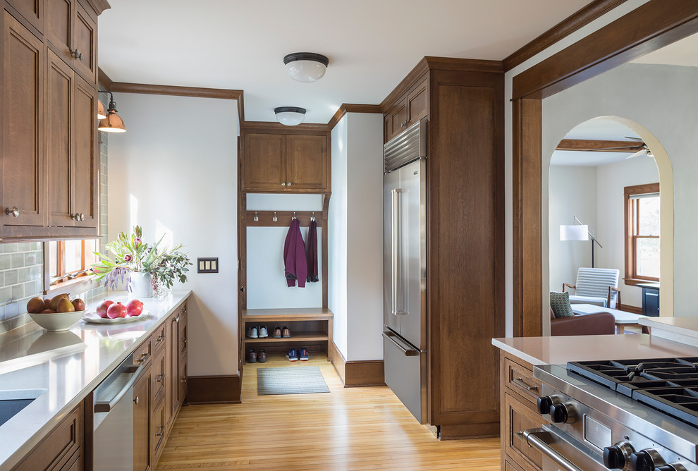 Eat-in kitchen - mid-sized craftsman galley light wood floor and brown floor eat-in kitchen idea in Minneapolis with an undermount sink, flat-panel cabinets, medium tone wood cabinets, quartz countertops, blue backsplash, ceramic backsplash, stainless steel appliances and no island