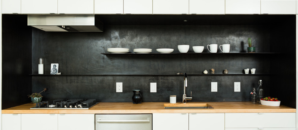 Imagen de cocina lineal retro de tamaño medio con fregadero bajoencimera, armarios con paneles lisos, puertas de armario blancas y encimera de madera