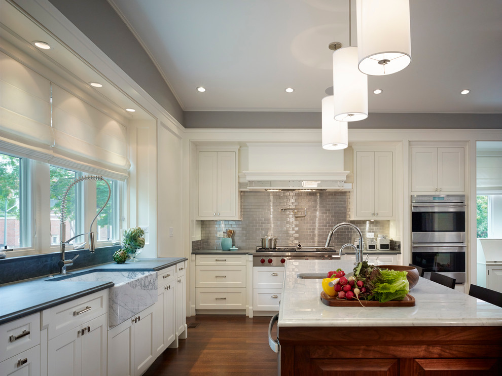 Inspiration for a large timeless u-shaped dark wood floor open concept kitchen remodel in Chicago with a farmhouse sink, recessed-panel cabinets, white cabinets, marble countertops, metallic backsplash, metal backsplash, paneled appliances and an island