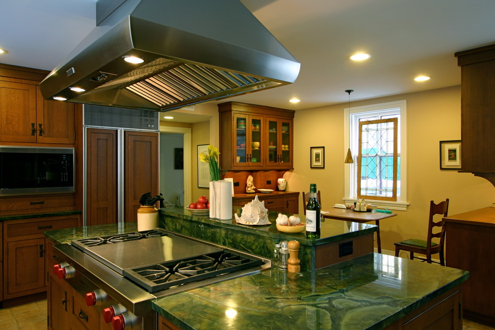 Imagen de cocina clásica renovada de tamaño medio con armarios estilo shaker, puertas de armario de madera oscura, electrodomésticos de acero inoxidable y una isla