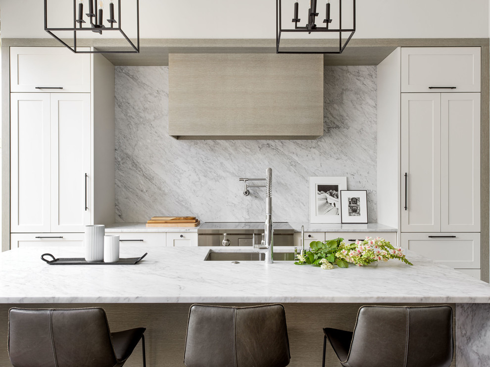 Contemporary kitchen in Chicago with a submerged sink, shaker cabinets, white cabinets, marble worktops, white splashback, marble splashback, stainless steel appliances, an island and white worktops.