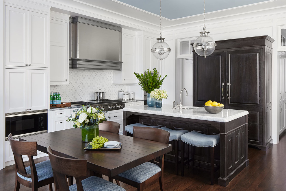 Eat-in kitchen - mid-sized traditional u-shaped dark wood floor and brown floor eat-in kitchen idea in Chicago with an undermount sink, raised-panel cabinets, black cabinets, marble countertops, white backsplash, ceramic backsplash, paneled appliances, an island and gray countertops
