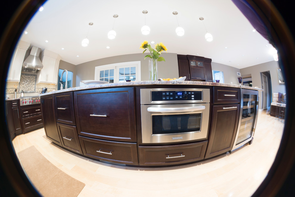 Example of a huge classic l-shaped light wood floor open concept kitchen design in Providence with an island, shaker cabinets, dark wood cabinets, granite countertops, beige backsplash, stone tile backsplash, stainless steel appliances and an undermount sink