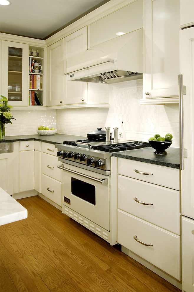Klassische Küche mit weißen Elektrogeräten, weißen Schränken, Küchenrückwand in Weiß und Speckstein-Arbeitsplatte in Chicago
