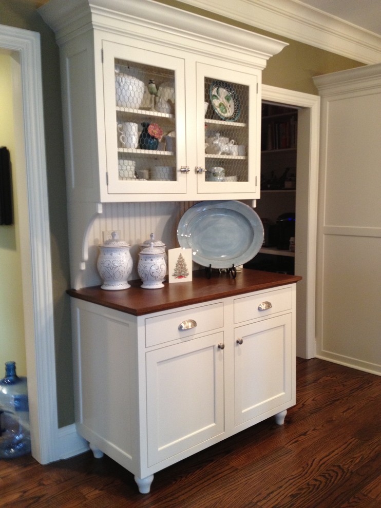 Immagine di una cucina lineare country chiusa con ante con riquadro incassato, ante bianche, top in legno e paraspruzzi bianco