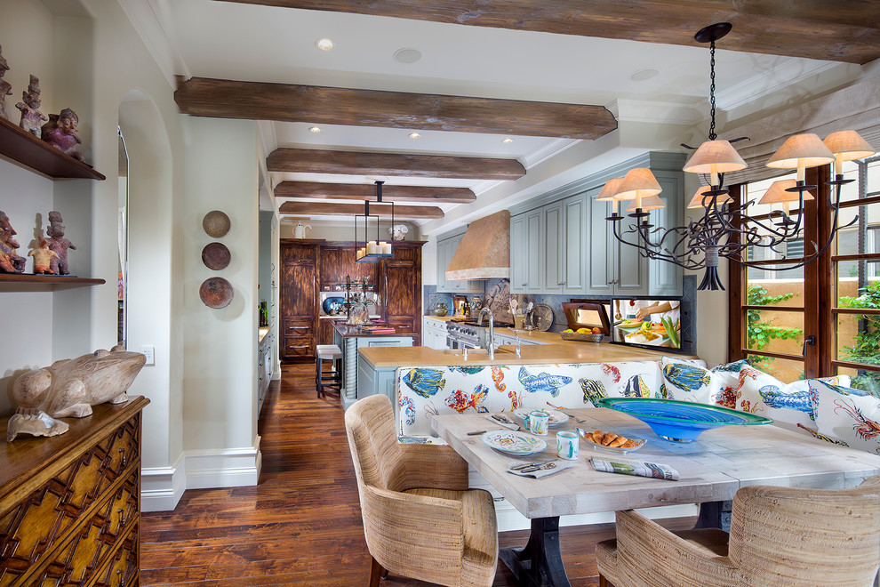 Medelhavsstil inredning av ett stort kök, med en rustik diskho, luckor med upphöjd panel, blå skåp, granitbänkskiva, blått stänkskydd, stänkskydd i mosaik, rostfria vitvaror, mellanmörkt trägolv och en köksö