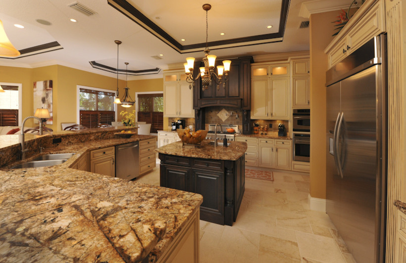 Exempel på ett klassiskt kök, med en dubbel diskho, luckor med upphöjd panel, granitbänkskiva, stänkskydd i mosaik och rostfria vitvaror