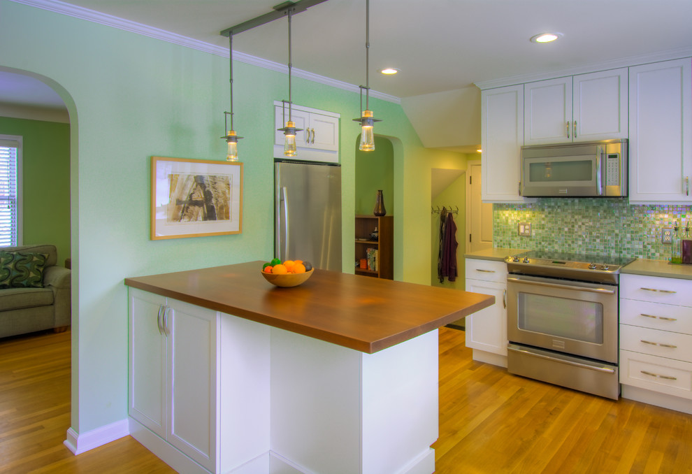 Example of a kitchen design in Detroit with wood countertops and an island