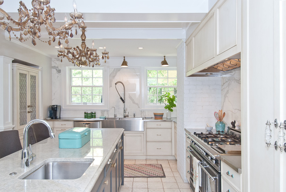 Example of a classic kitchen design in Chicago with stainless steel countertops, an undermount sink, recessed-panel cabinets, white backsplash, stainless steel appliances and marble backsplash