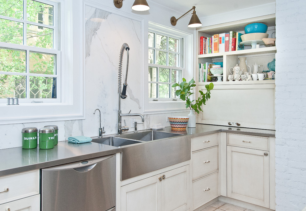 Exempel på ett klassiskt kök, med en integrerad diskho, luckor med infälld panel, vita skåp, bänkskiva i rostfritt stål, vitt stänkskydd, stänkskydd i sten och rostfria vitvaror