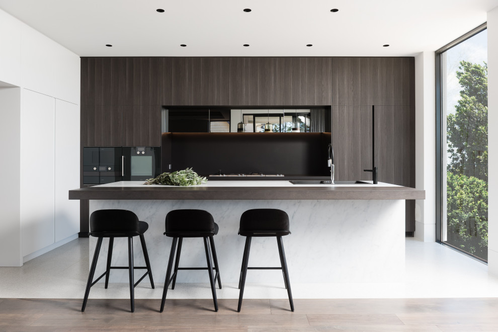 Moderne Küche mit Einbauwaschbecken, flächenbündigen Schrankfronten, dunklen Holzschränken, schwarzen Elektrogeräten, Kücheninsel und weißem Boden in Sydney