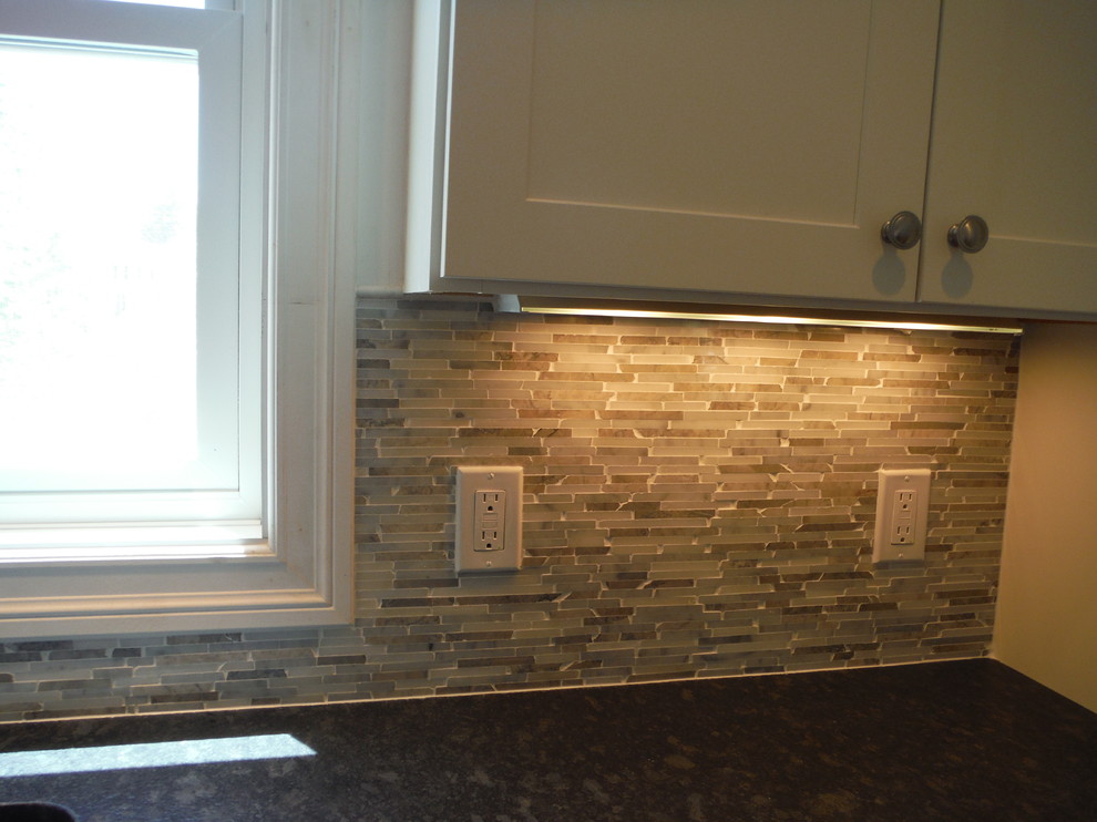 Exempel på ett klassiskt l-kök, med skåp i shakerstil, vita skåp, granitbänkskiva, beige stänkskydd och stänkskydd i mosaik