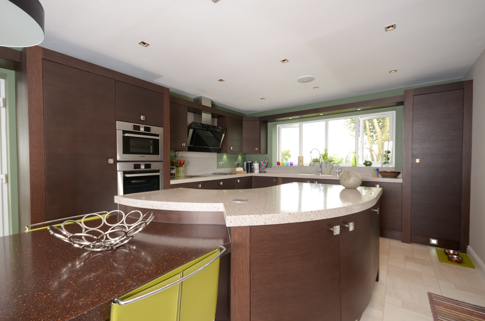 Medium sized contemporary single-wall kitchen/diner in Manchester with a submerged sink, flat-panel cabinets, dark wood cabinets, composite countertops, stainless steel appliances and an island.
