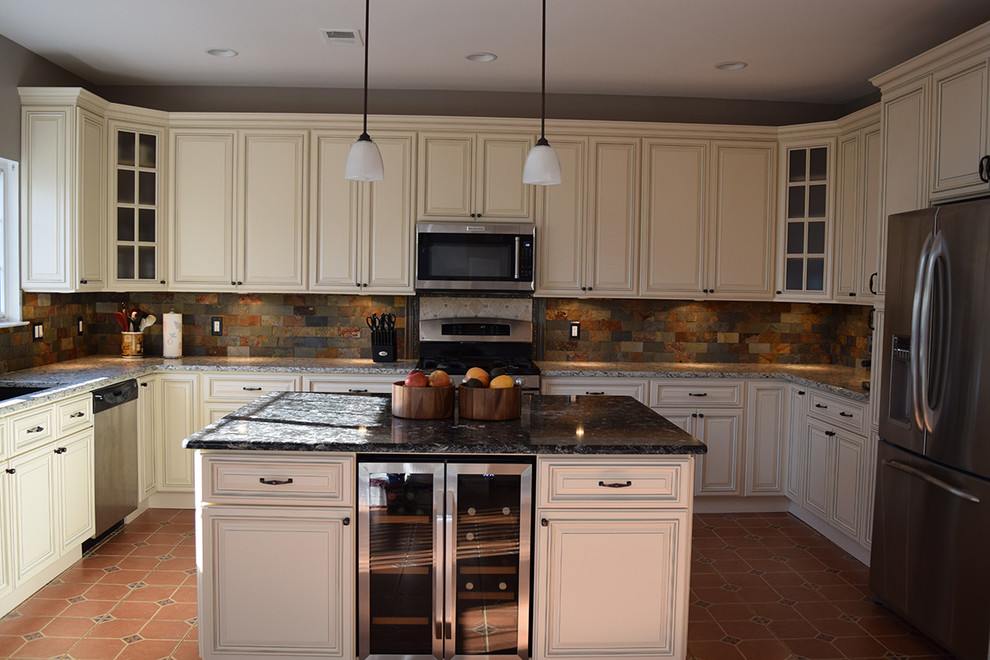 Inspiration för ett mellanstort vintage kök, med en undermonterad diskho, luckor med upphöjd panel, vita skåp, granitbänkskiva, flerfärgad stänkskydd, stänkskydd i stenkakel, rostfria vitvaror, klinkergolv i terrakotta, en köksö och rött golv