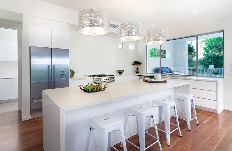 Foto di una cucina contemporanea con ante lisce, ante bianche, top in quarzo composito, paraspruzzi bianco e elettrodomestici in acciaio inossidabile