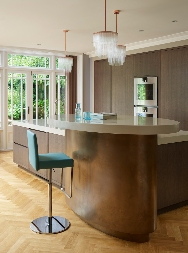 Contemporary kitchen/diner in London with an integrated sink, flat-panel cabinets, dark wood cabinets, granite worktops, integrated appliances, medium hardwood flooring and an island.