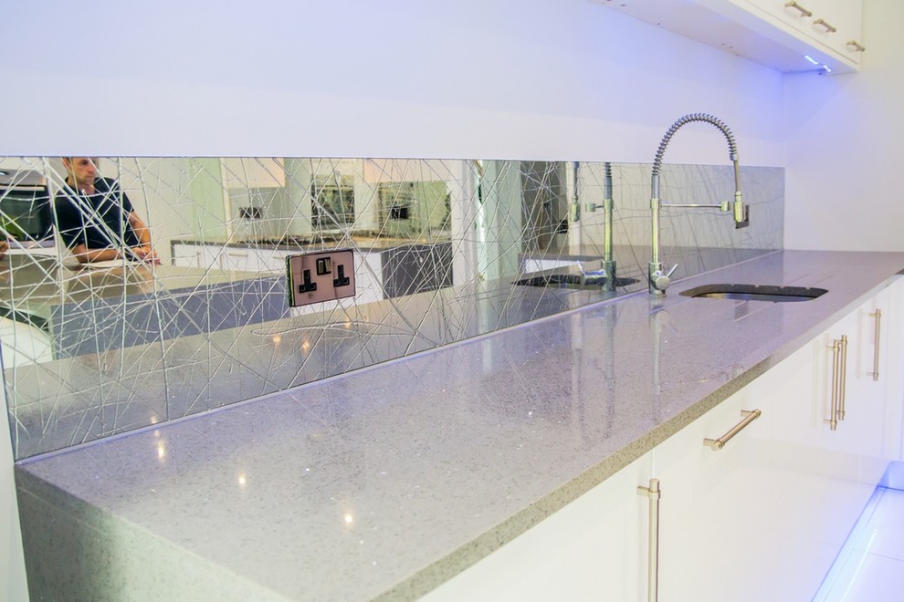 Photo of a modern kitchen in Hertfordshire with mirror splashback.