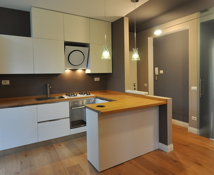 Foto di una cucina contemporanea di medie dimensioni con lavello da incasso, ante bianche e elettrodomestici bianchi