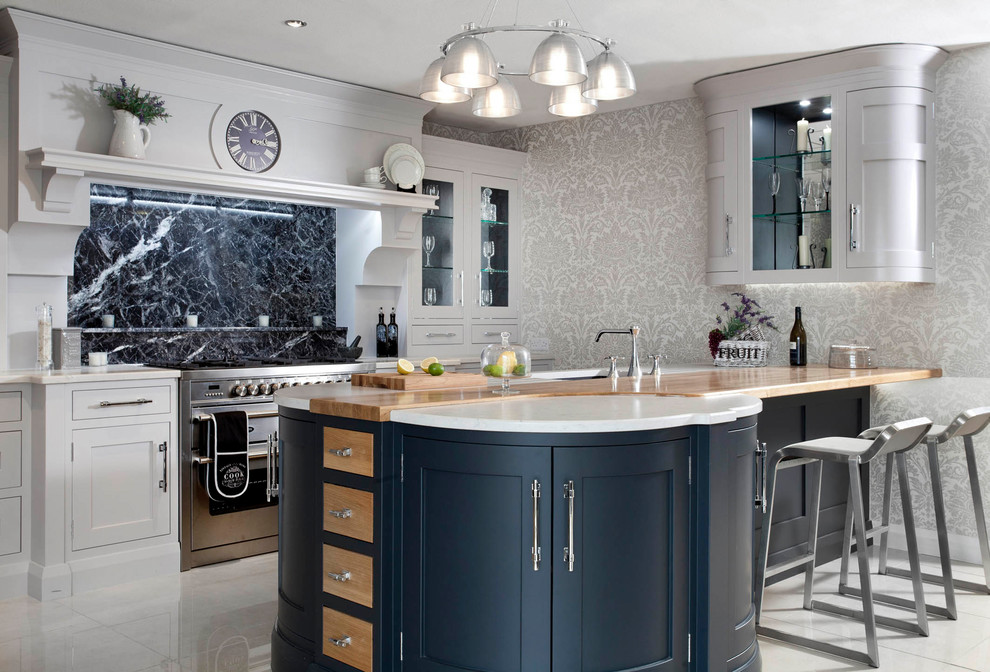 Example of a mid-sized classic single-wall porcelain tile and gray floor eat-in kitchen design in Belfast with an undermount sink, shaker cabinets, gray cabinets, quartzite countertops, black backsplash, marble backsplash, stainless steel appliances and an island