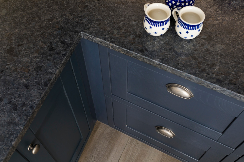 Example of a mid-sized mountain style u-shaped vinyl floor enclosed kitchen design in Kent with a double-bowl sink, shaker cabinets, blue cabinets, granite countertops, gray backsplash, stone slab backsplash, black appliances and a peninsula