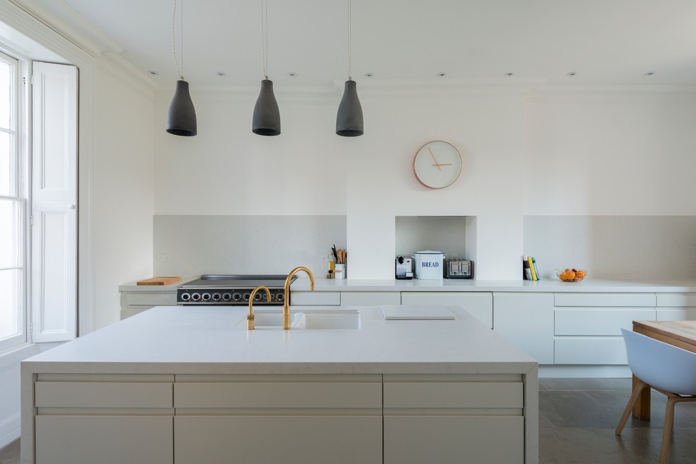 Zweizeilige Moderne Wohnküche mit Unterbauwaschbecken, flächenbündigen Schrankfronten, weißen Schränken, Küchengeräten aus Edelstahl und Kücheninsel in London