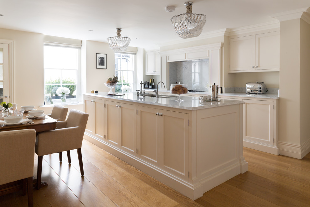 Medium sized traditional grey and cream single-wall kitchen/diner in London with a built-in sink, shaker cabinets, beige cabinets, marble worktops, stainless steel appliances, medium hardwood flooring, no island, brown floors and grey worktops.